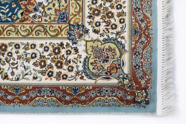 A close-up of a Qaleen Carpets rug with intricate floral patterns and a border, showcasing the company's high-quality and