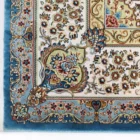 A close-up of a Qaleen Carpets rug with intricate floral patterns and a blue border, showcasing the company's high-quality