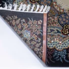 A close-up of a Qaleen Carpets rug's corner, showing its intricate design and pattern