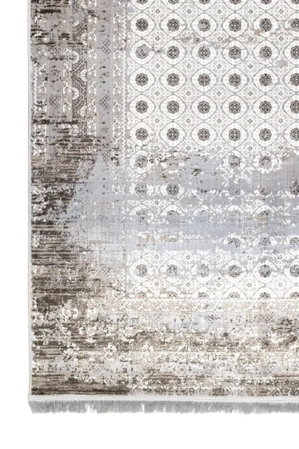 A close-up of a Qaleen Carpets rug with a distressed, vintage-inspired design, featuring a mix of neutral colors and a