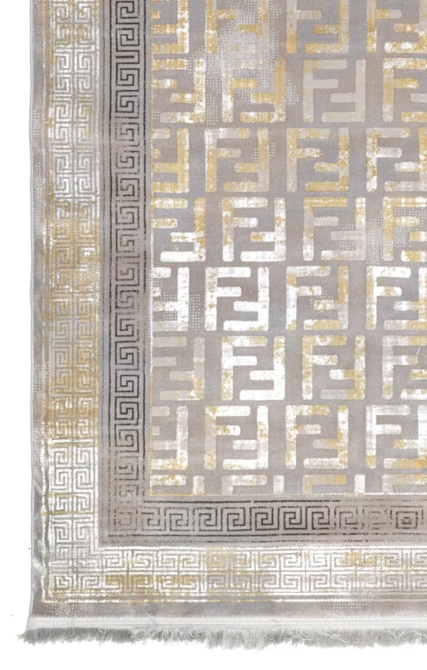 A close-up of a Qaleen Carpets rug with a traditional design, featuring a mix of gold and silver patterns on a grey