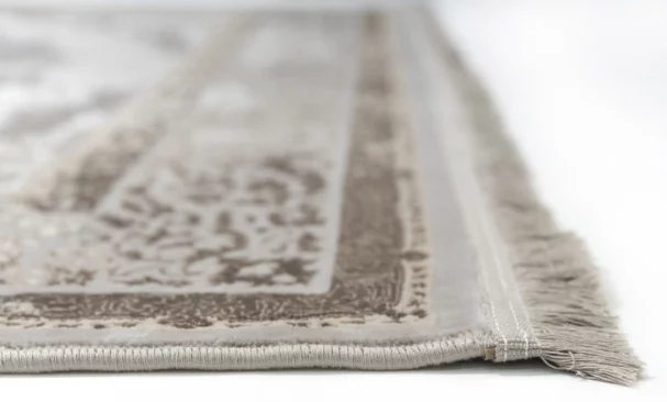 A close-up of a Qaleen Carpets rug with a soft, neutral color palette and intricate patterns, showcasing its high-quality