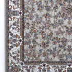 A close-up of a Qaleen Carpets rug with a floral pattern, featuring a mix of flowers and leaves in various colors on a