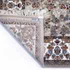 A close-up of a Qaleen Carpets rug with a floral pattern, featuring a mix of flowers and leaves in various colors, with a
