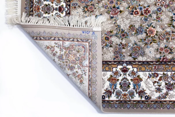 A close-up of a Qaleen Carpets rug with a floral pattern, featuring a mix of flowers and leaves in various colors, with a