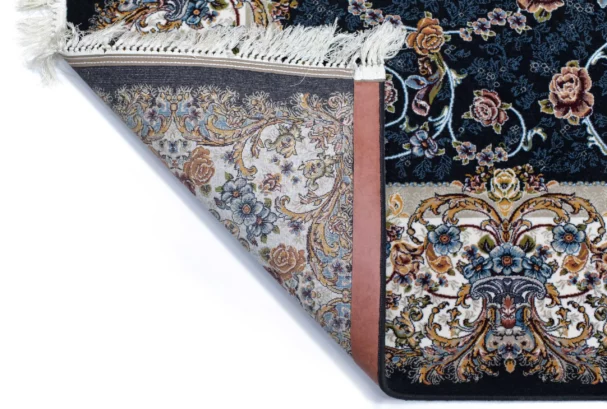 A close-up of a Qaleen Carpets rug with a floral pattern, featuring a mix of blue, gold, and white colors, with a fringe on