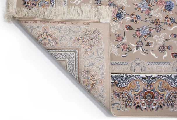 A close-up of a Qaleen Carpets rug with a floral pattern, featuring a mix of pastel colors and a fringe at the top