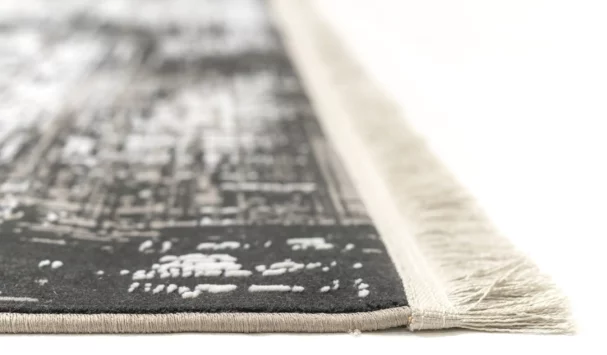 A close-up of a rug's edge, with a focus on the fringe and the rug's pattern, made by Qaleen Carpets