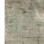 A close-up of a Qaleen Carpets rug with a unique, hand-knotted design and a soft, muted color palette