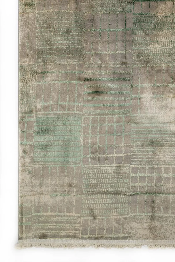 A close-up of a Qaleen Carpets rug with a unique, hand-knotted design and a soft, muted color palette