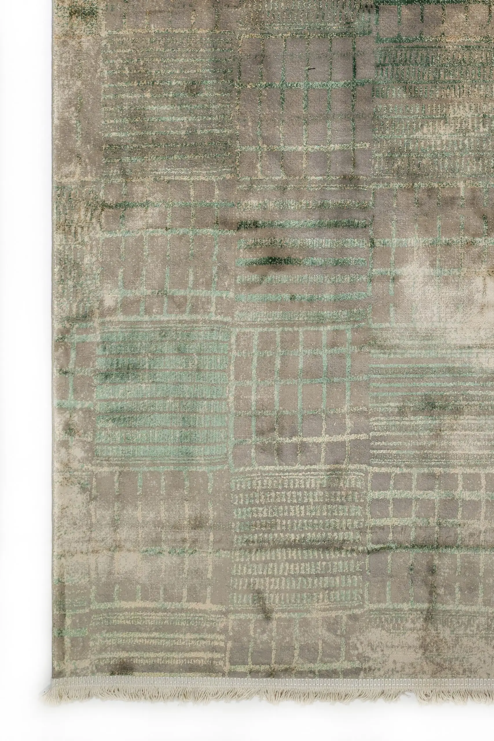 A close-up of a Qaleen Carpets rug with a unique, hand-knotted design and a soft, muted color palette