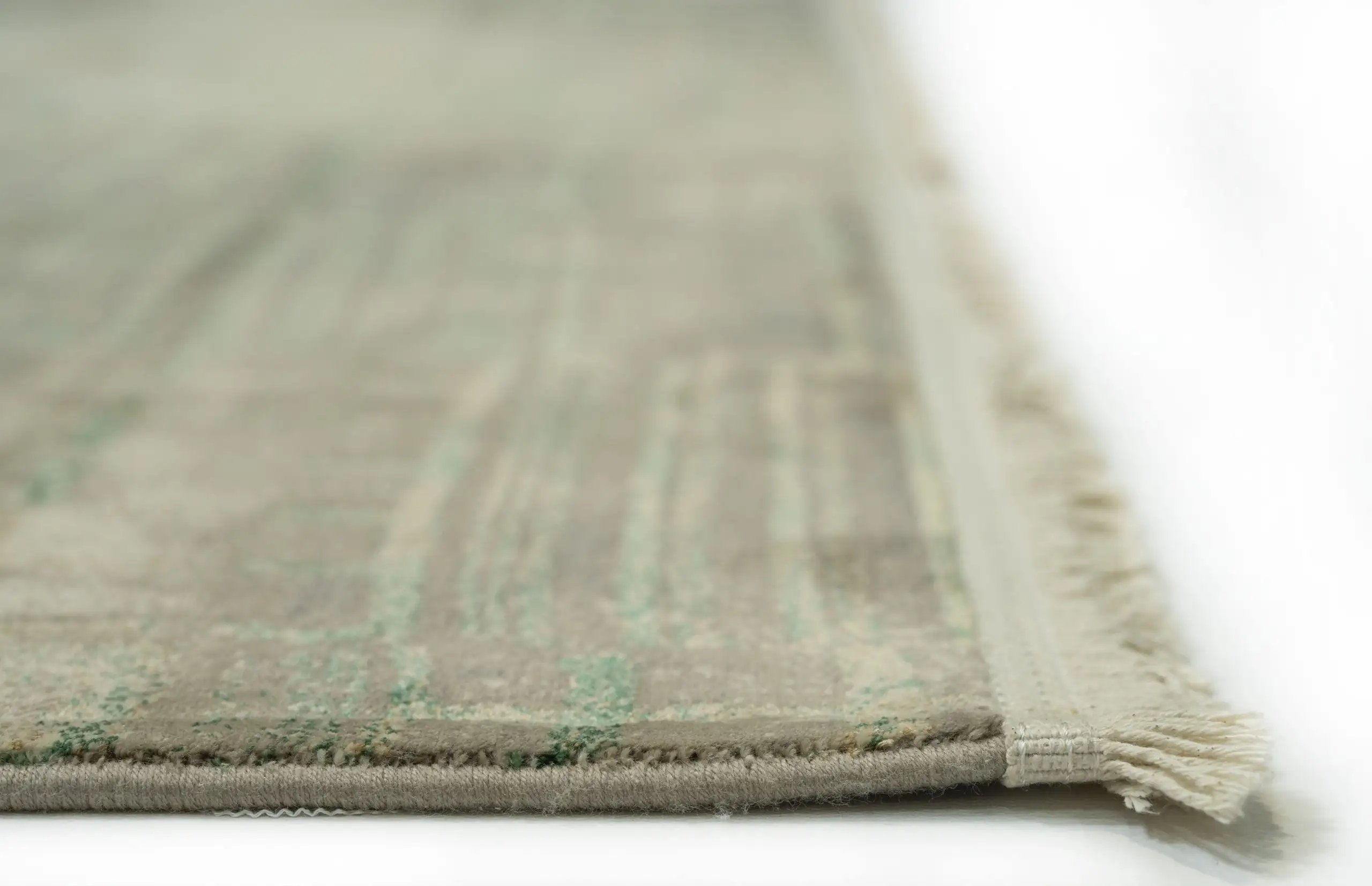 A close-up of a Qaleen Carpets rug with a subtle, muted color palette and a soft, woven texture