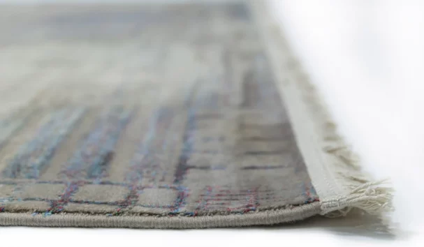 A close-up of a Qaleen Carpets rug with a subtle, intricate design and a soft, muted color palette