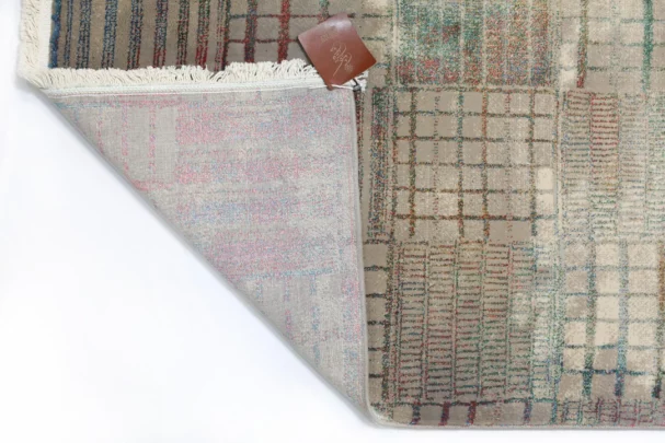 A Qaleen Carpets rug with a unique blend of traditional and modern design elements, featuring a mix of colors and patterns,