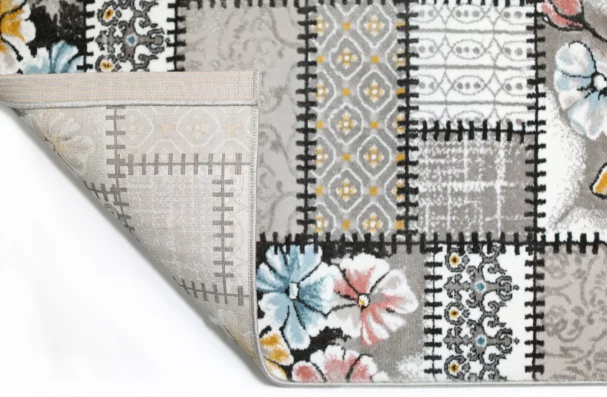 Carpets A close-up of a rug's edge, with a pattern of flowers and a border of intricate designs, showcasing the quality of
