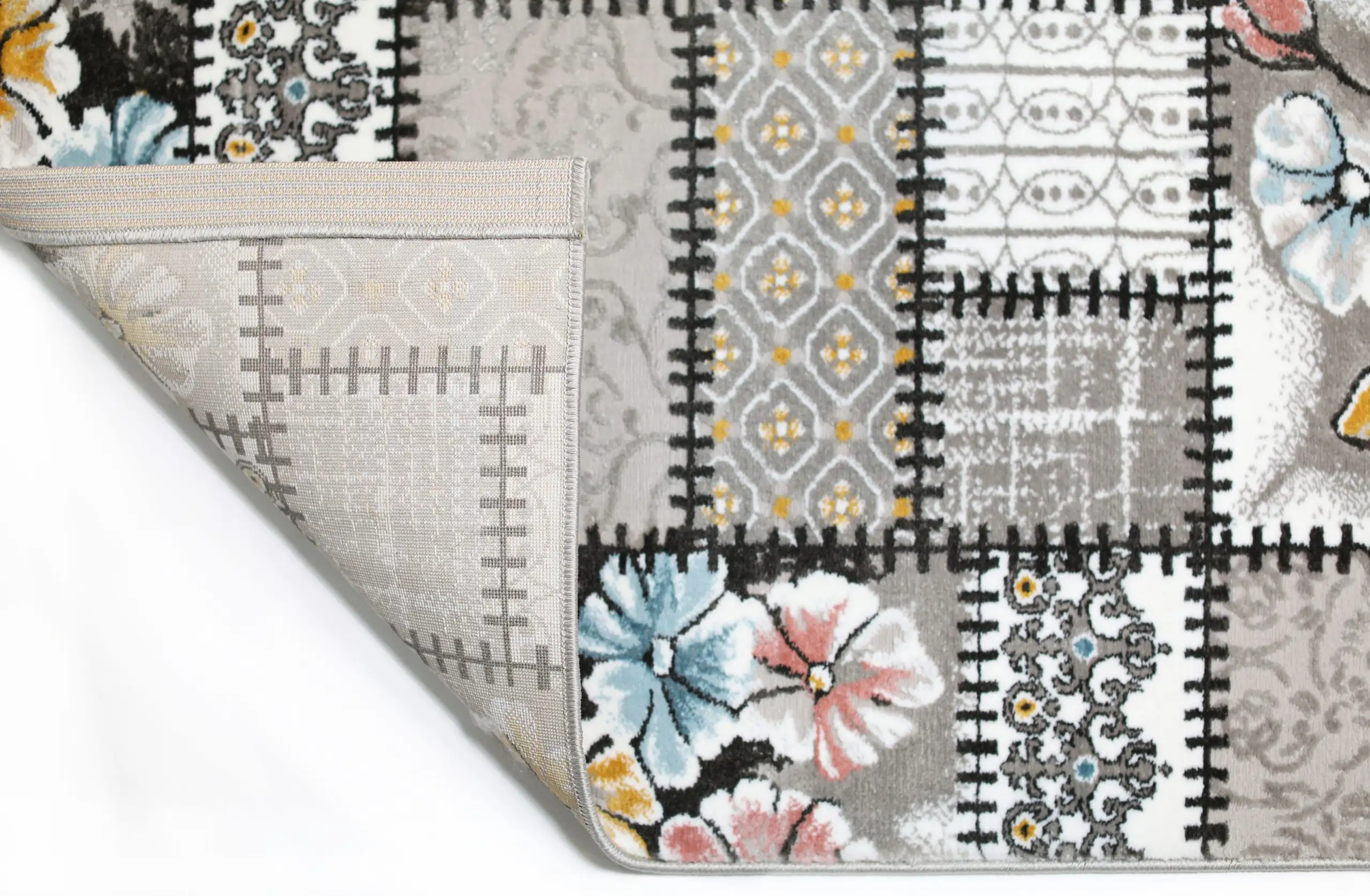 Carpets A close-up of a rug's edge, with a pattern of flowers and a border of intricate designs, showcasing the quality of