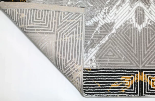 Qaleen Carpets A close-up of a rug's corner, with a patterned design and a white background