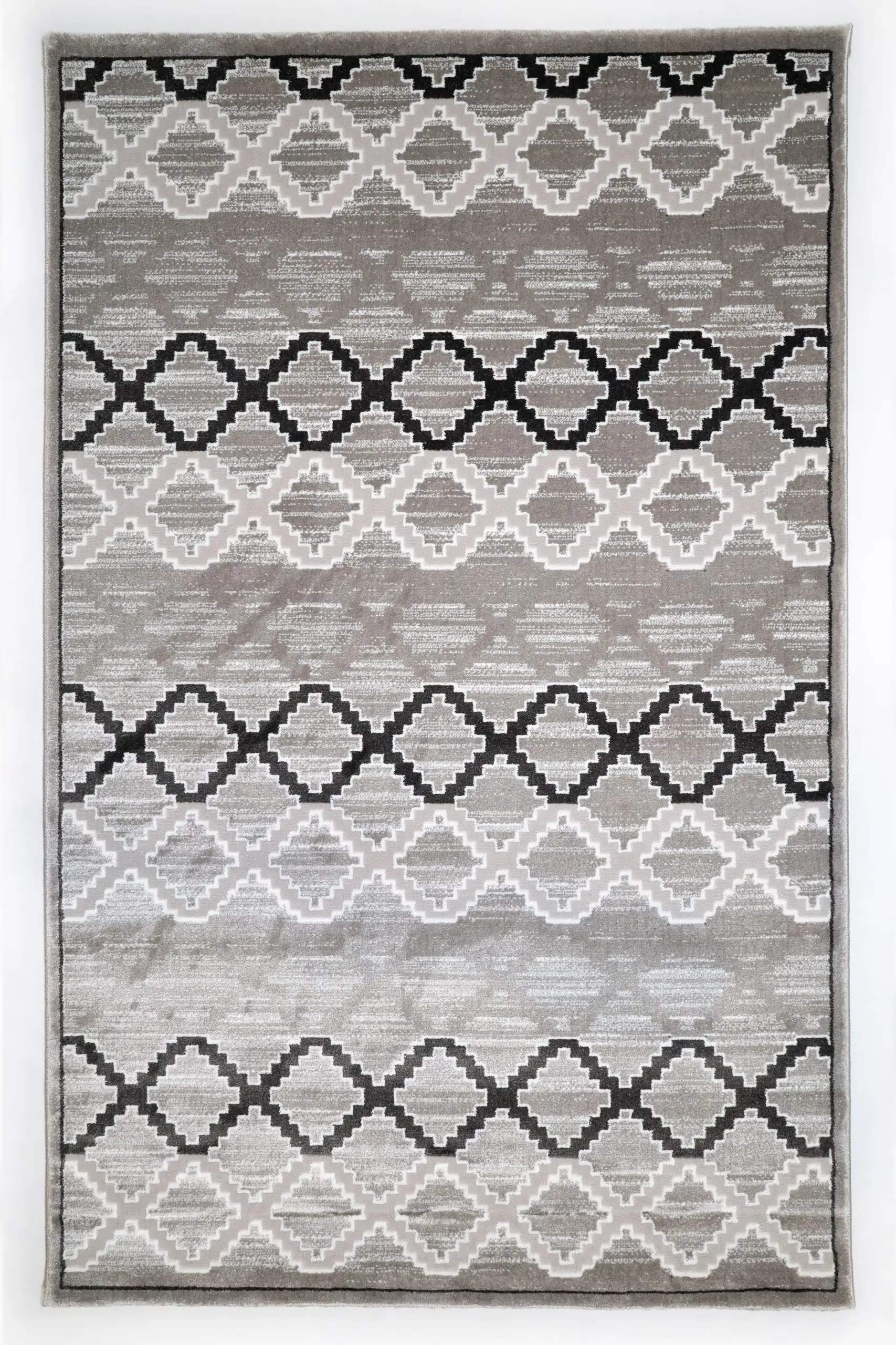 A high-quality, intricately designed rug with a mix of grey, white, and black patterns, made by Qaleen Carpets