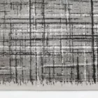 A close-up of a gray and white rug with a subtle, abstract pattern, made by Qaleen Carpets