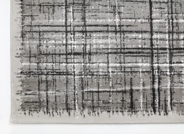 A close-up of a gray and white rug with a subtle, abstract pattern, made by Qaleen Carpets