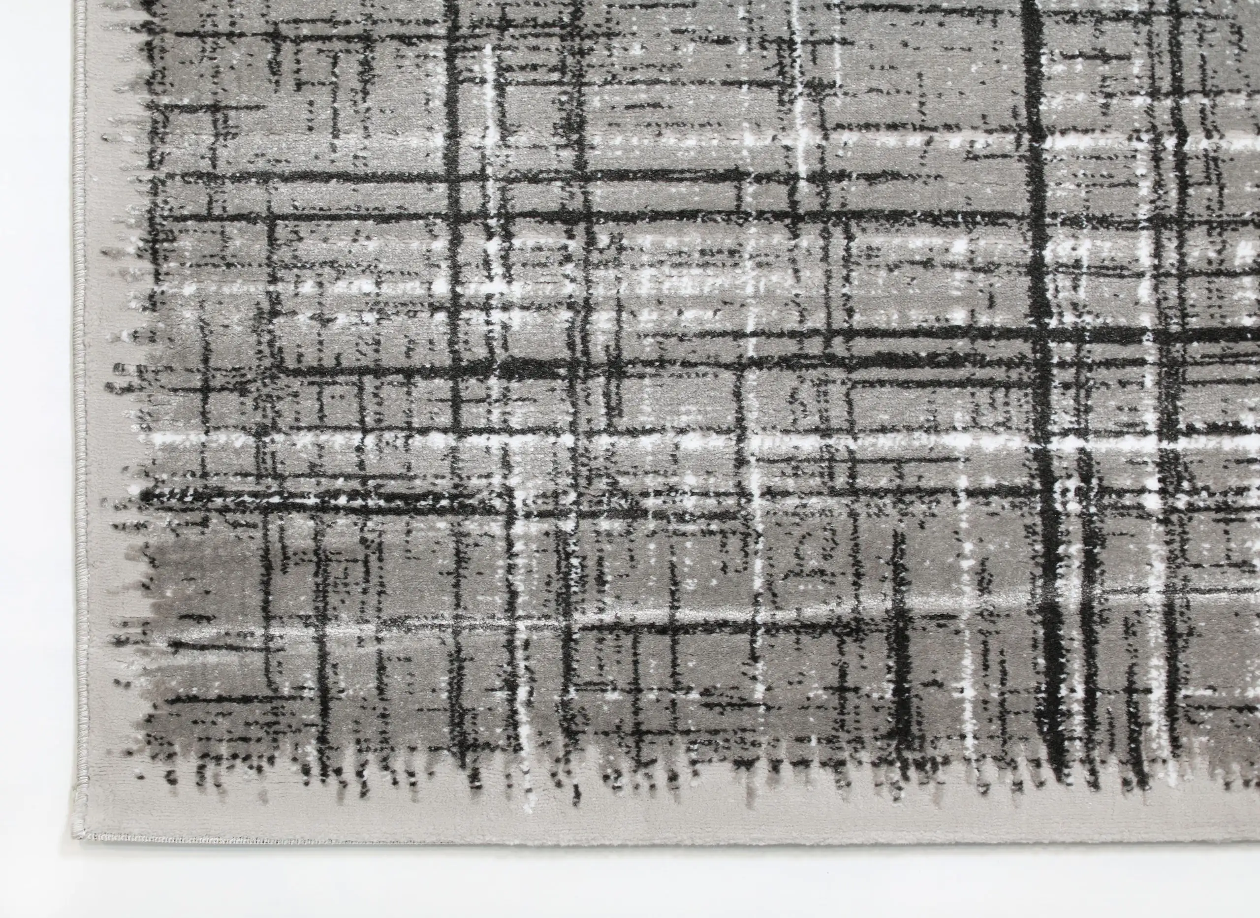 A close-up of a gray and white rug with a subtle, abstract pattern, made by Qaleen Carpets