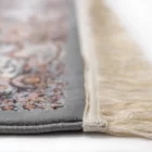 A close-up of a Qaleen Carpets rug with a fringe, showcasing its intricate design and high-quality materials
