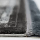 A close-up of a Qaleen Carpets rug's edge, with a focus on its fringe and border