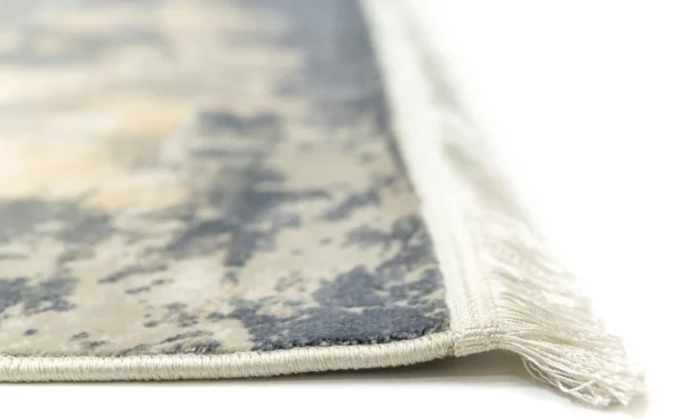 A close-up of a Qaleen Carpets rug's edge, showcasing its intricate design and soft, white fringe