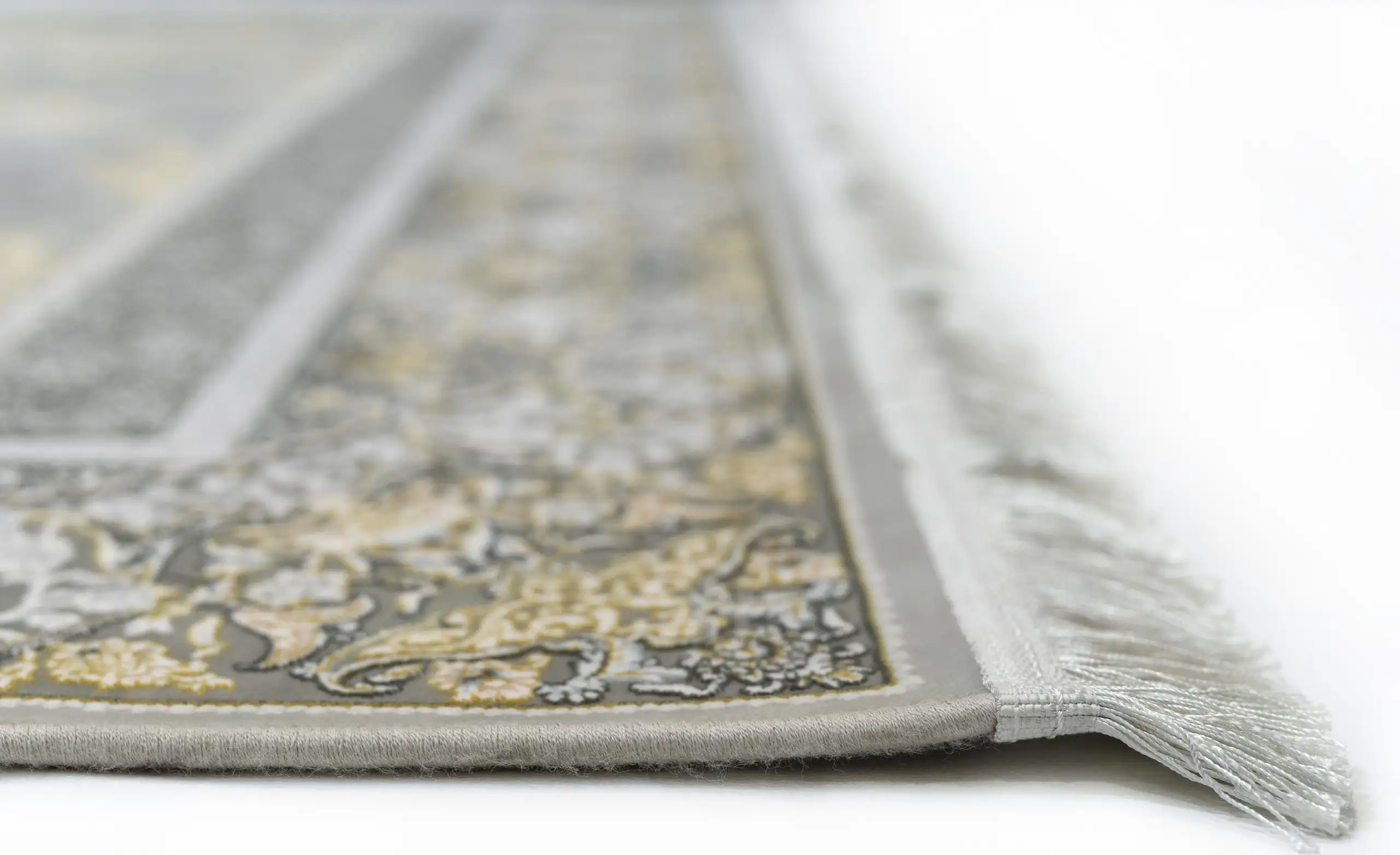Carpets A close-up view of a carpet's edge, showcasing its intricate design and delicate fringes