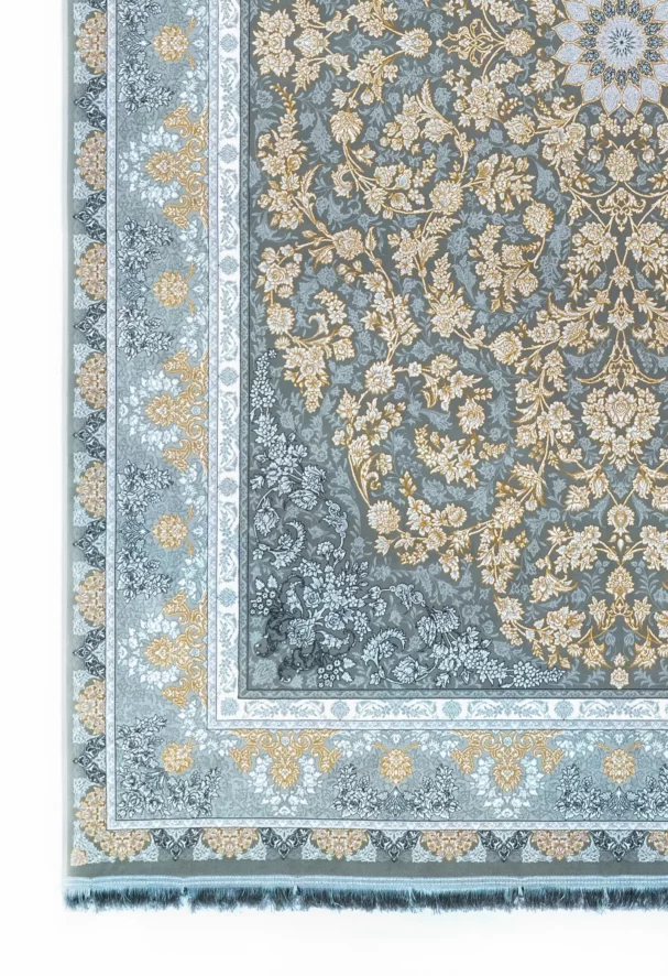 A close-up of a Qaleen Carpets rug with a floral pattern and fringe, set against a white background