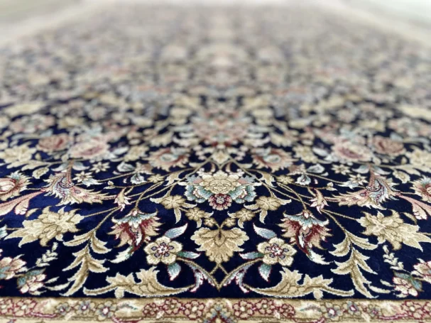 A beautiful, intricately designed carpet with a rich, dark blue background and intricate gold and red patterns, showcasing