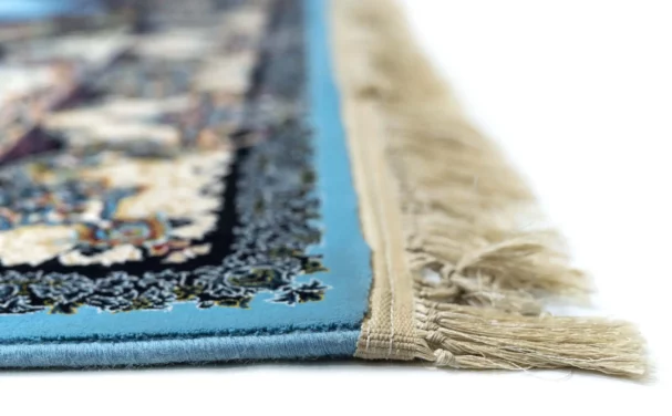 A close-up of a carpet's edge, with a blue border and intricate patterns, showcasing the beauty of carpets and rugs