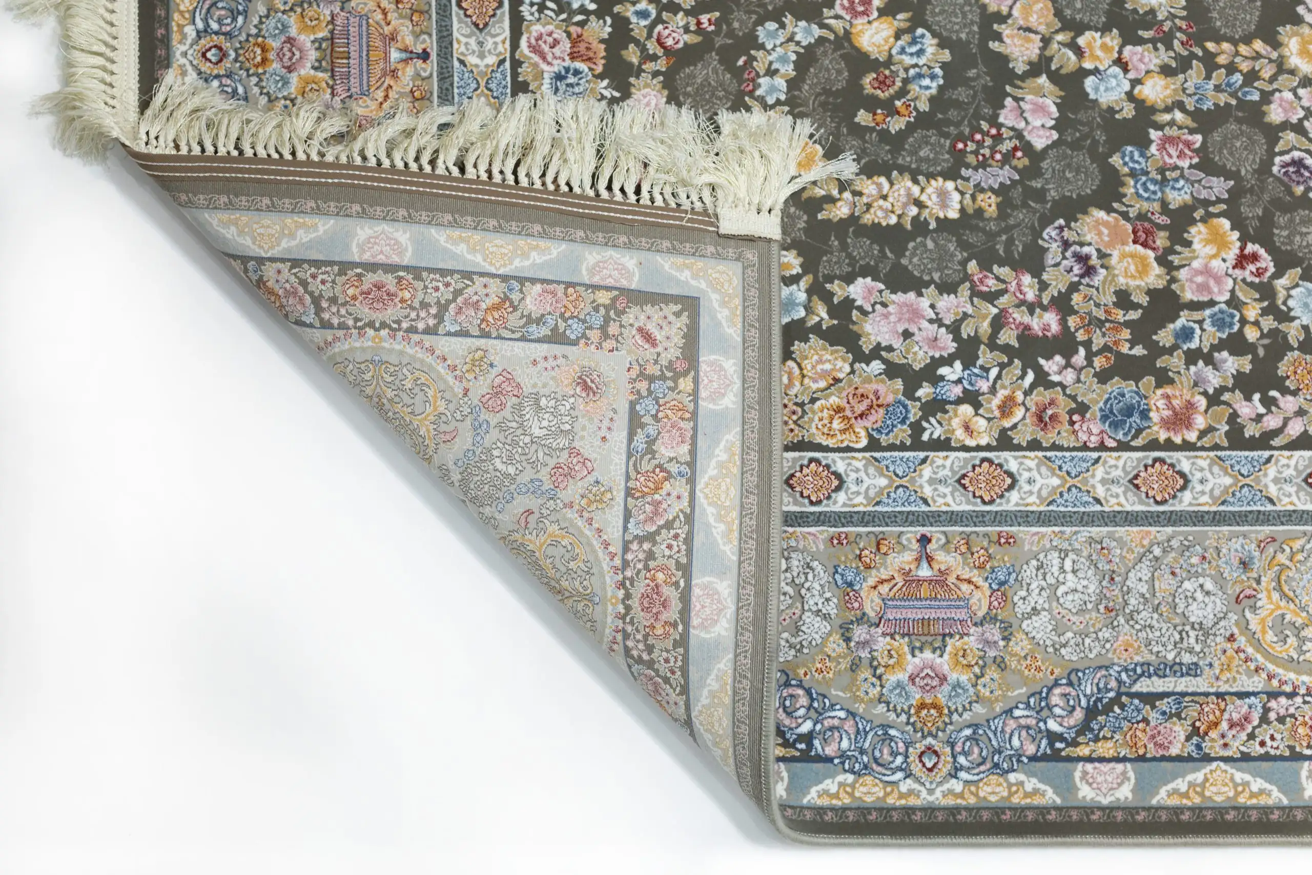 A Qaleen Carpets rug with a floral pattern and fringe, partially unrolled to show its design and quality