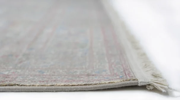 A close-up view of a Qaleen Carpets rug, showcasing its intricate patterns and soft, natural colors