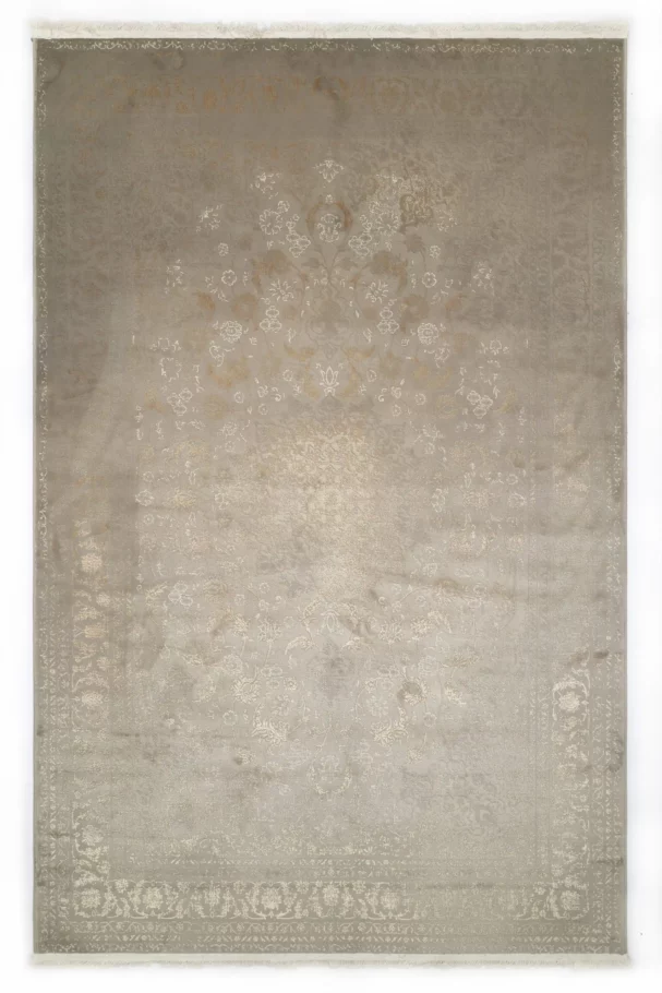 A Qaleen Carpets rug with a light grey background and intricate, white, floral patterns