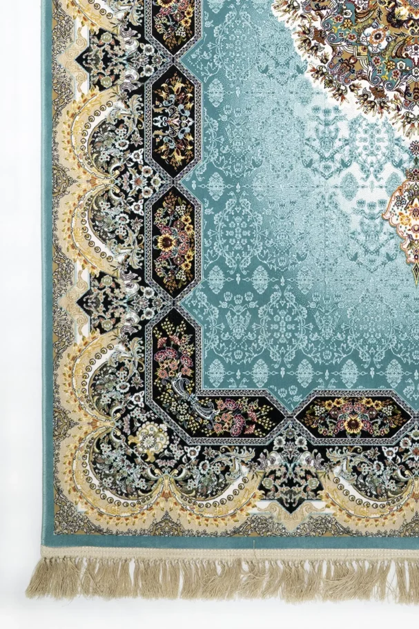 A close-up of a Qaleen Carpets rug with a blue and gold pattern, featuring a central hexagonal design and a border of
