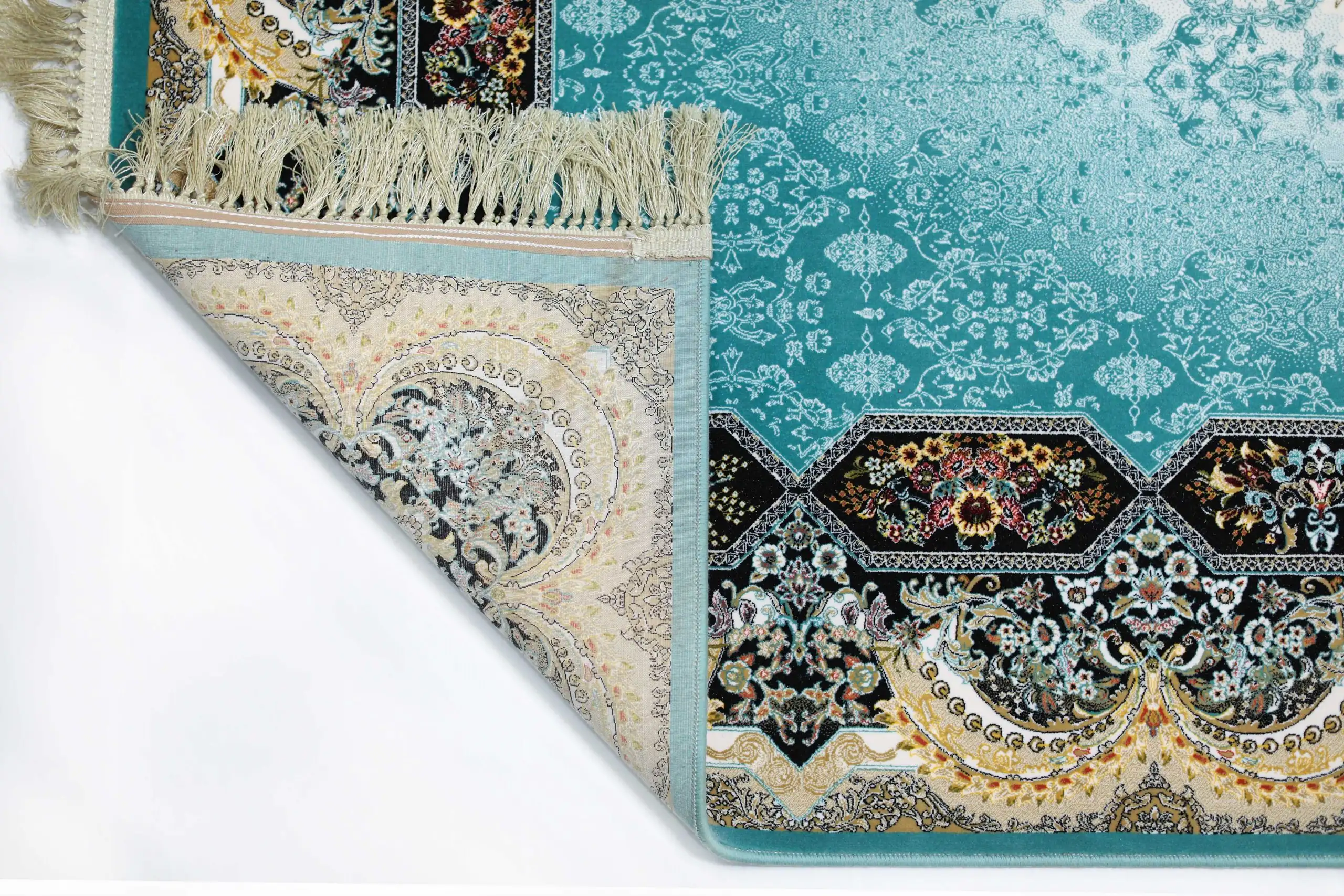 A close-up of a rug with a blue and white pattern, featuring a fringe at the top and a corner folded over to show the rug's
