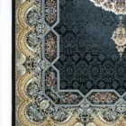 A close-up of a Qaleen Carpets rug with intricate patterns and a dark blue background, featuring a mix of gold, white, and