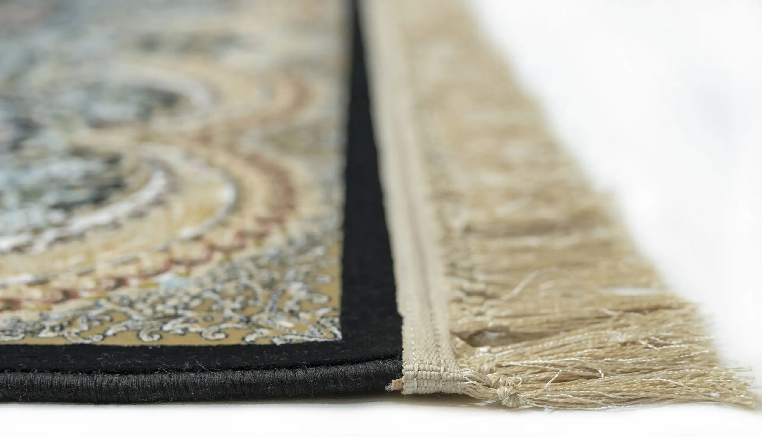 A close-up view of a Qaleen Carpets rug, focusing on its intricate design and fringe, with a focus on its quality and