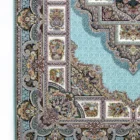 A close-up of a Qaleen Carpets rug with intricate patterns and a light blue background, featuring a mix of floral and