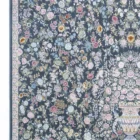 A Qaleen Carpets rug with a dark blue background and a floral pattern of various flowers and leaves in pastel colors, with a