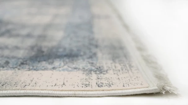 A close-up of a Qaleen Carpets rug with a subtle, intricate design and a soft, neutral color palette