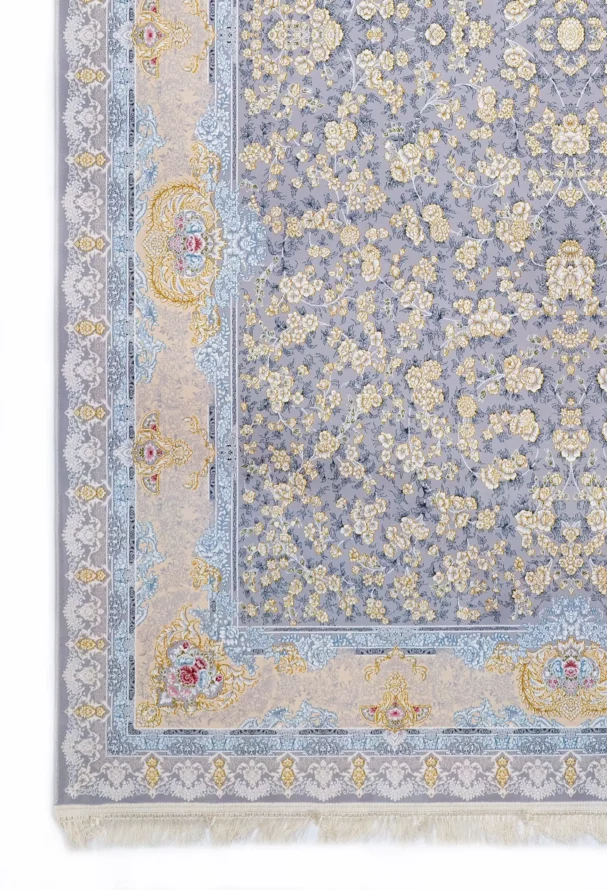 A Qaleen Carpets rug with a light grey background, intricate gold and blue floral patterns, and a fringe at the bottom