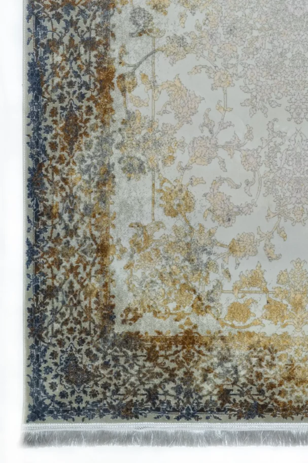 A close-up of a Qaleen Carpets rug with a floral pattern in muted colors, featuring a mix of gold, blue, and brown hues on a