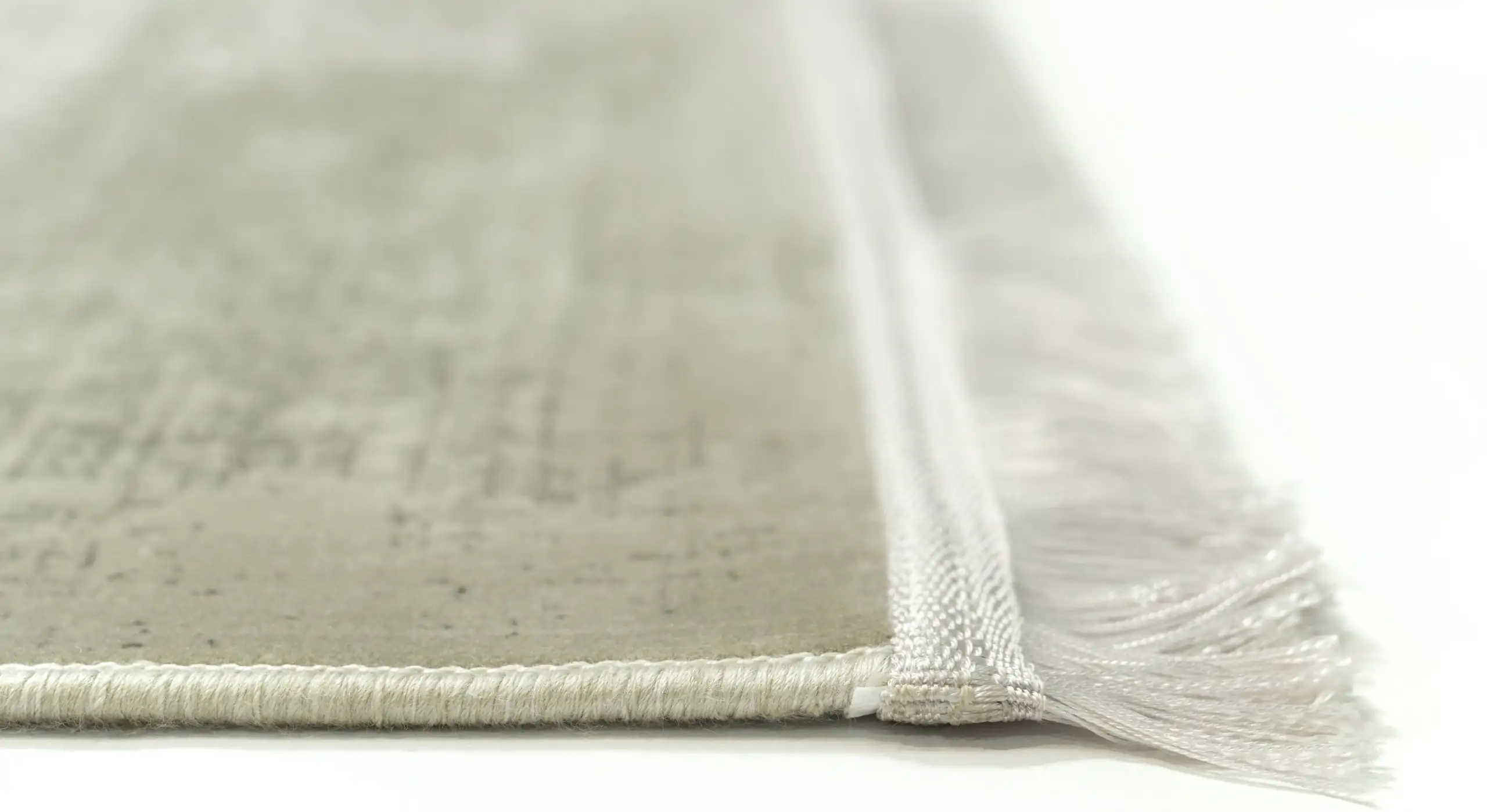 Qaleen Carpets A close-up of a rug's edge, with a white background