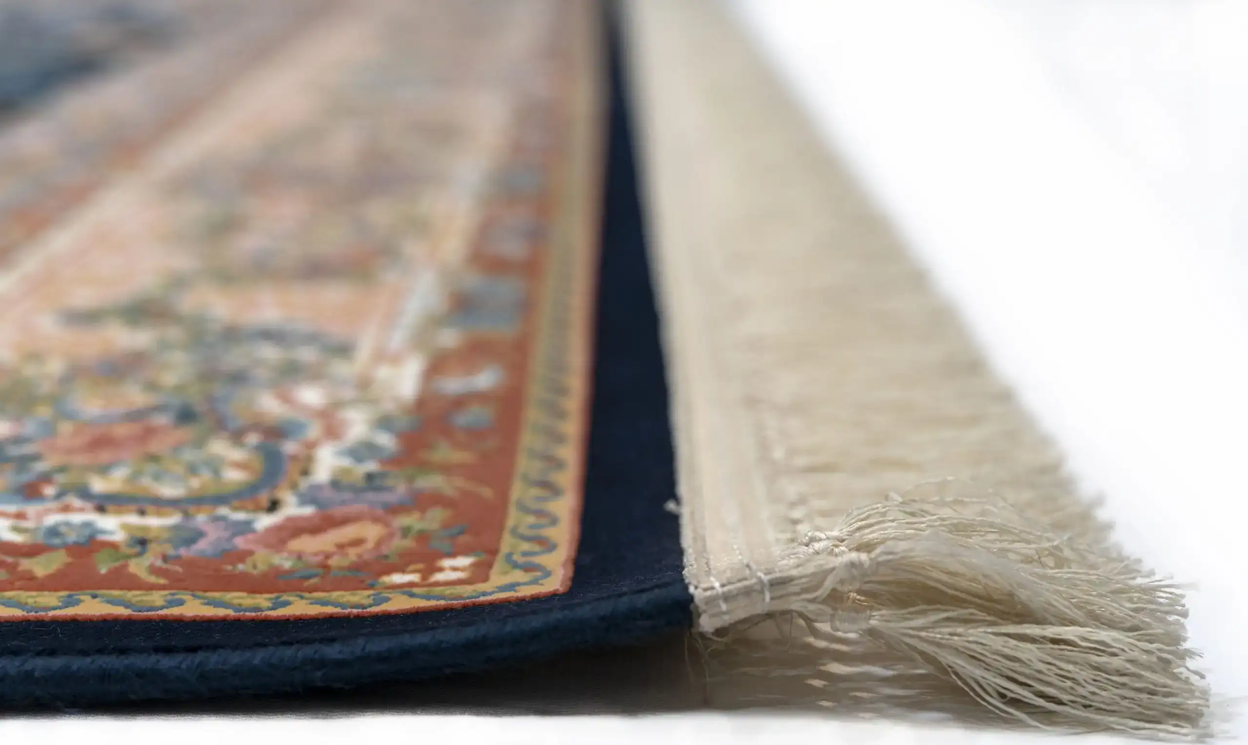 A close-up of a rug's edge, with a focus on the intricate carpeting and rug's design, showcasing the beauty of carpets and
