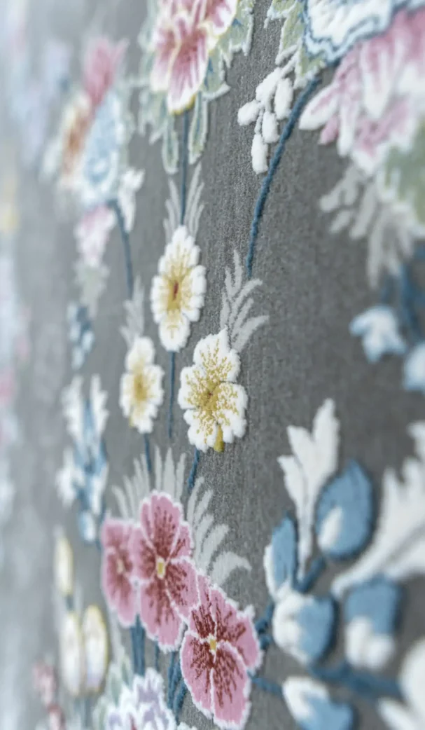 Carpets A close-up of a carpet with a floral pattern, featuring a mix of pink, white, and yellow flowers on a gray background