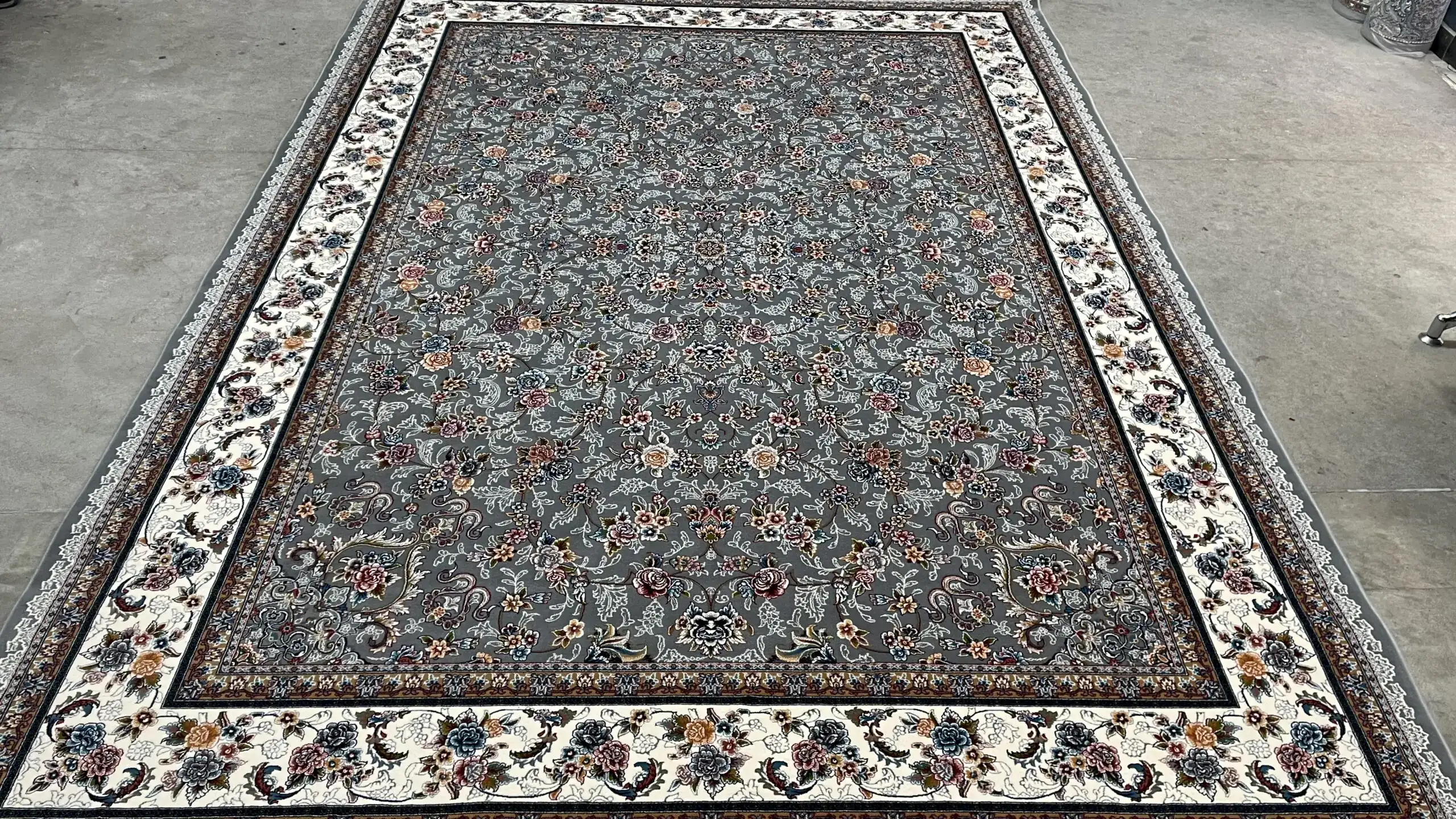 Carpets A large, intricately patterned carpet with a central grey area surrounded by a white border, with a mix of red,